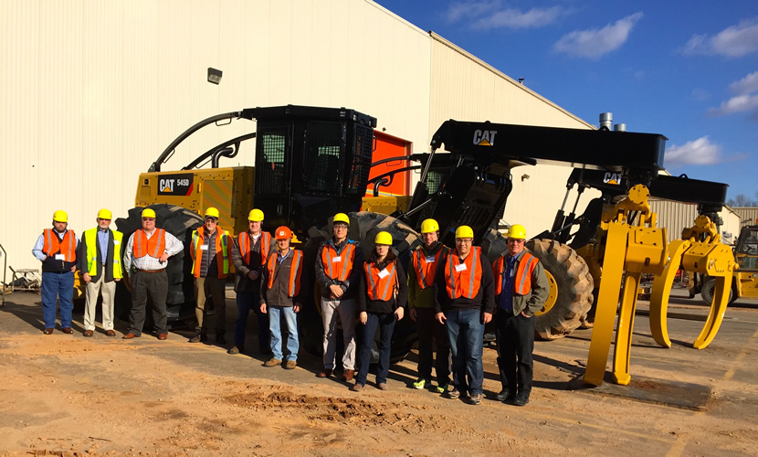 workers standing in front of harvesting equipment